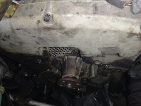 1993 Ford Taurus - Close-up view of an engine water pump, with a metal grille visible above.