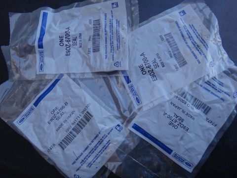 1993 Ford Taurus - Multiple sealed packages of genuine Ford parts are shown, including seals with part numbers E9DZ-6700-A and E9DZ-6700-B.