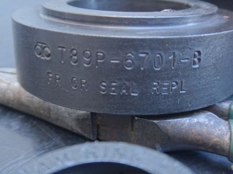 1993 Ford Taurus - A metal component, possibly a seal or bearing, is marked with part numbers and "FR CR SEAL REPL".