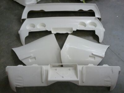 1976 Chevrolet Corvette - Unpainted body kit parts for a Chevrolet Corvette, including front and rear bumpers and fender sections.