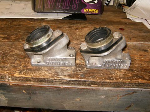 2000 Ford E350 - Two aluminum intake manifolds with rubber boots are shown on a wooden surface.