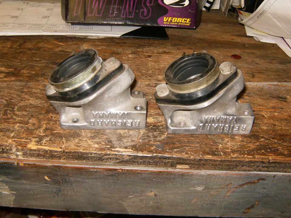 Two aluminum intake manifolds with rubber boots, labeled REICHARD YAMAHA