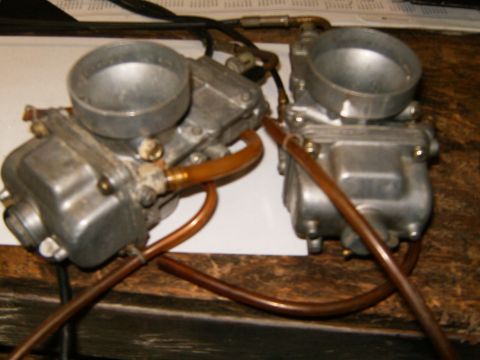2000 Ford E350 - Pair of carburetors with copper fuel lines, likely for a motorcycle.