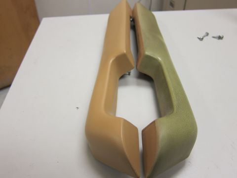 1987 Dodge 1500 - Two car door pull handles, one tan and one light green, are displayed on a white surface with two screws nearby.