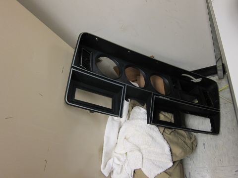 1987 Dodge 1500 - A black dashboard bezel with chrome trim is shown, cutouts for gauges and other components.