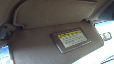 1996 Ford Bronco - Interior view of a vehicle's sun visor with a caution label.