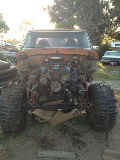 1969 Ford F-250 - This heavily modified pickup truck is missing its front end, revealing the engine bay and massive off-road tires.
