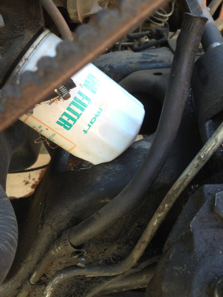 Oil filter with green text on a vehicle engine