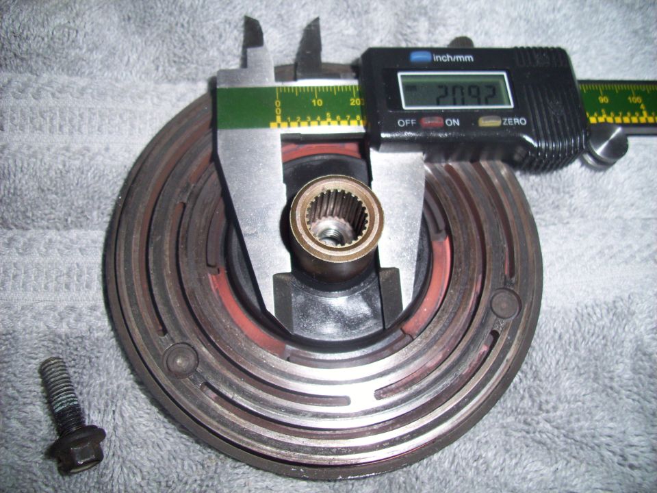 Digital caliper measuring a clutch assembly. A bolt is to the left