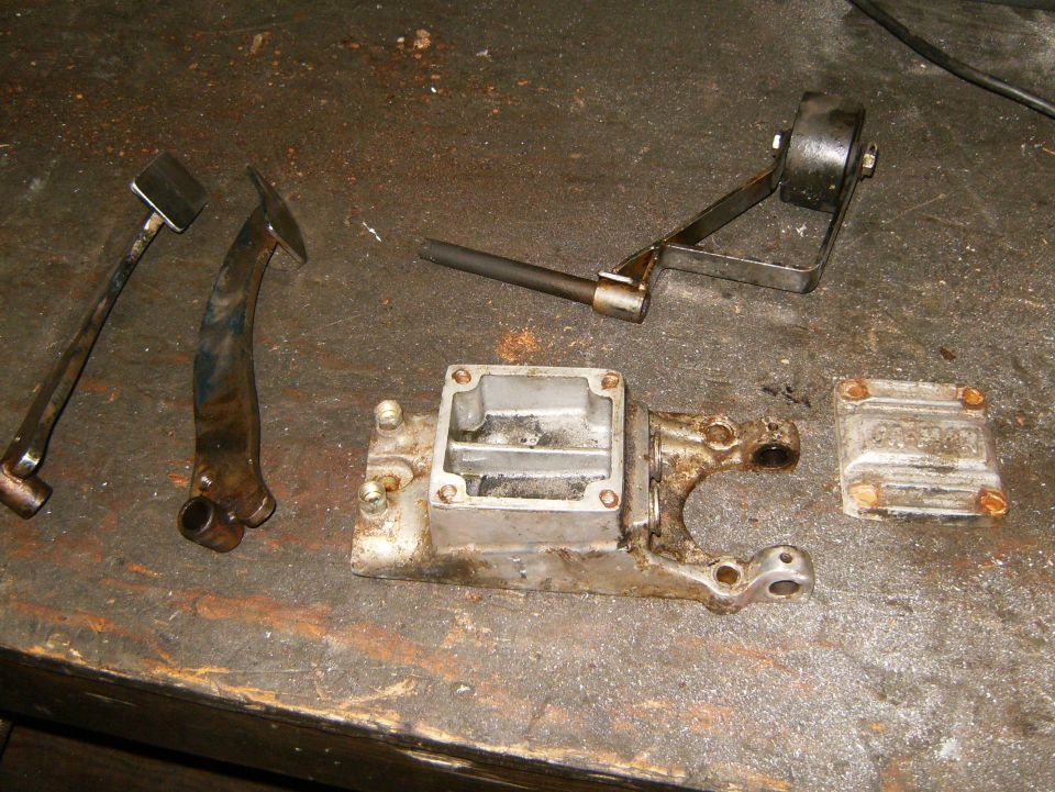 Brake master cylinder housing and cap with linkage parts on workbench