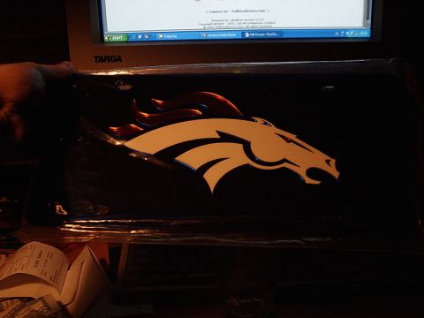 1996 Ford Bronco - A close-up of a Ford Bronco logo is visible on a dark surface, with a computer screen and a hand in the background.