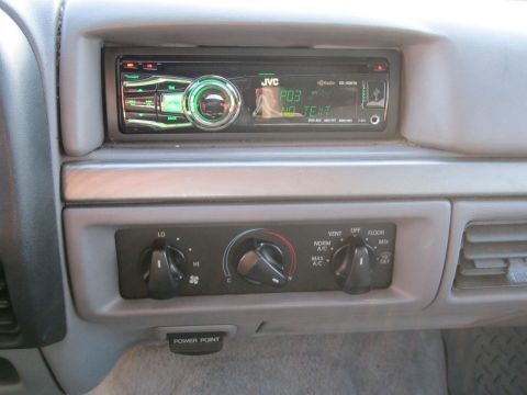1994 Ford Bronco - Close-up of a car's interior, showing the dashboard with an aftermarket JVC radio and manual climate controls.