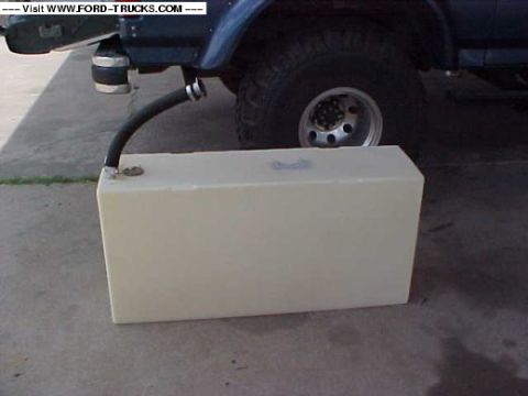 1992 Ford Bronco - A 1992 Ford Bronco is partially visible with an auxiliary fuel tank and hose attached to its undercarriage.