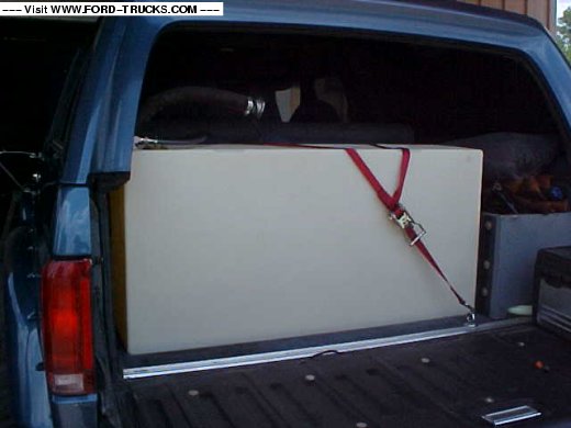Rear view of a 1992 Ford Bronco with a large white tank secured in the cargo area
