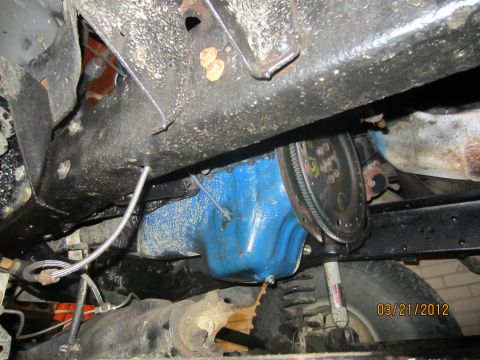 1979 Ford Bronco - Underside view of a vehicle's drivetrain components, including the oil pan and flywheel.