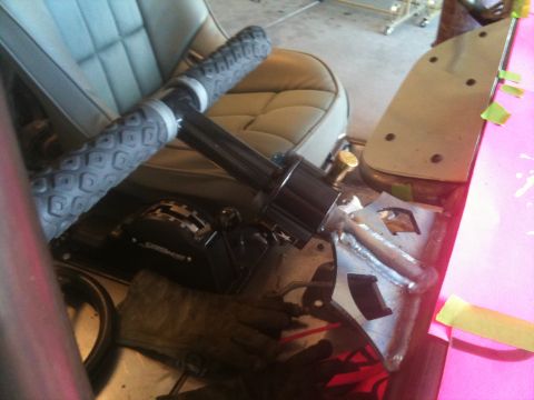 1966 Ford Bronco - Close-up of a vehicle's interior, showing the steering column, throttle, and seats.