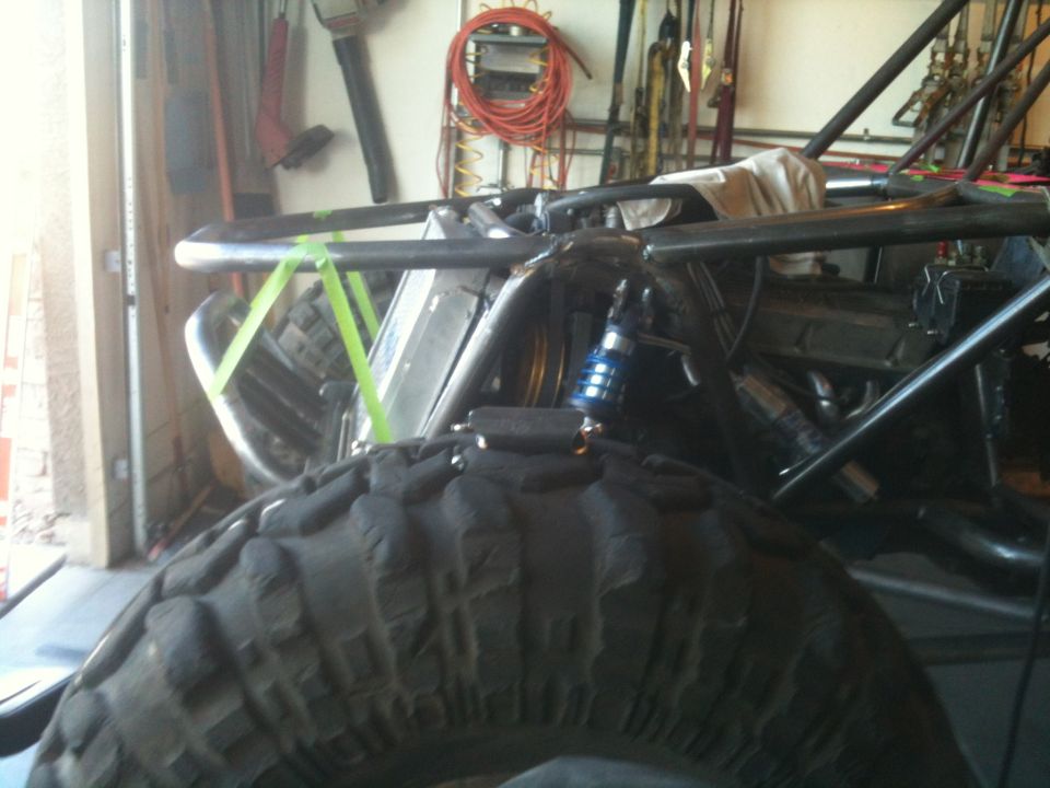 Close-up of a buggy's tire and roll cage in a garage
