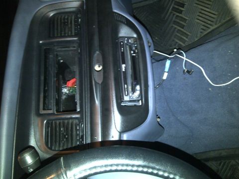 2000 Ford Crown Victoria - Aftermarket stereo installed in a car's dashboard, with visible wiring and a partially removed dash panel.