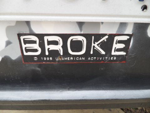1994 Jeep Cherokee - Sticker with text BROKE and 1996 UNAMERICAN ACTIVITIES is visible on a vehicle part.