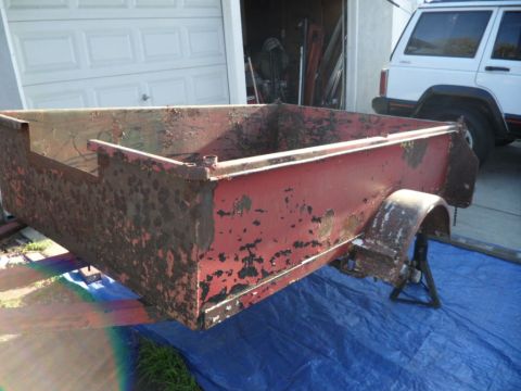 1994 Jeep Cherokee - A rusty red trailer sits in front of a garage, with a white Jeep Cherokee parked behind it.