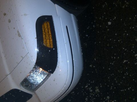 2000 Ford Crown Victoria - Close-up of a white car's front fender and turn signal assembly.