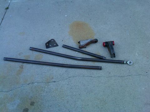 1986 Ford Bronco - Automotive steering and suspension parts are laid out on a concrete surface.