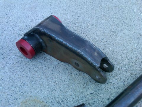 1986 Ford Bronco - Custom steering part with red bushings shown on a concrete surface.