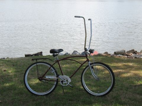 1994 Ford Bronco - Cruiser bicycle with tall handlebars parked on grass by the water.
