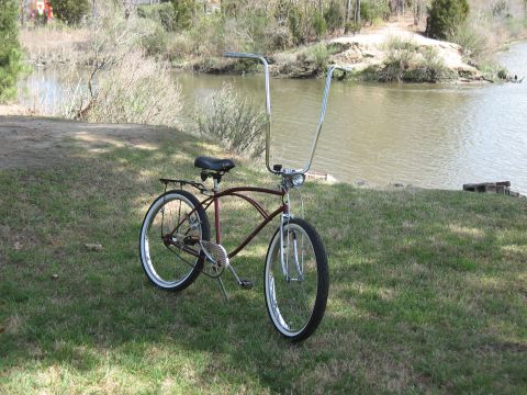1994 Ford Bronco - A classic cruiser bicycle sits on a grassy bank next to a calm lake.