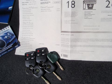 2000 Jaguar S-Type - Window sticker and keys for a 2000 Jaguar S-Type are laid out on a dark surface.