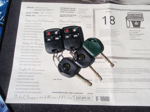 2000 Jaguar S-Type - A close-up of car keys and a window sticker detailing the features and price of a 2000 Jaguar S-Type.