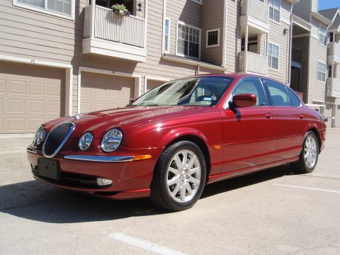 2000 Jaguar S-Type - A red 2000 Jaguar S-Type is parked outside a residential building.