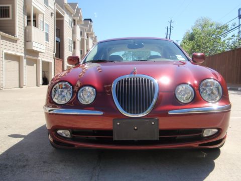 2000 Jaguar S-Type - Front view of a red Jaguar S-Type sedan parked in front of townhouses.