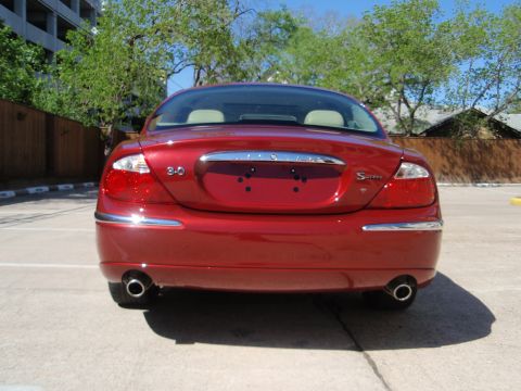 2000 Jaguar S-Type - The rear of a red Jaguar S-Type sedan is shown, dual exhaust pipes and chrome trim.