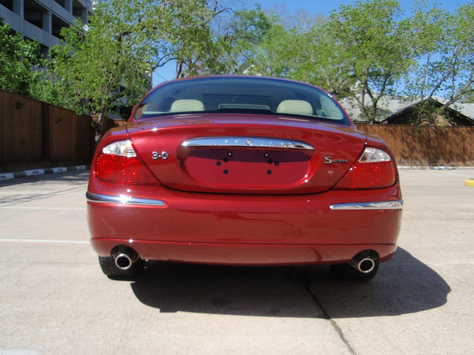 Rear view of a red Jaguar S-Type with '3.0' and 'S-Type' badges visible