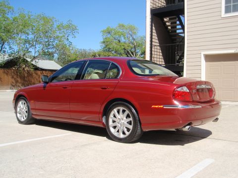 2000 Jaguar S-Type - Rear 3/4 view of a red 2000 Jaguar S-Type sedan parked in a lot.