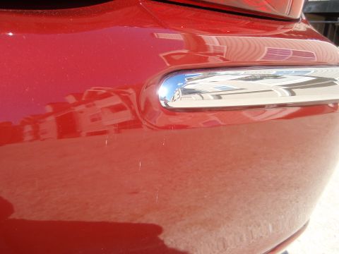 2000 Jaguar S-Type - Rear bumper detail on a red vehicle, showing a chrome trim piece.