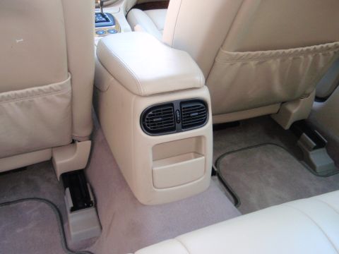 2000 Jaguar S-Type - The rear interior of a vehicle shows the center console with air vents and a storage compartment.