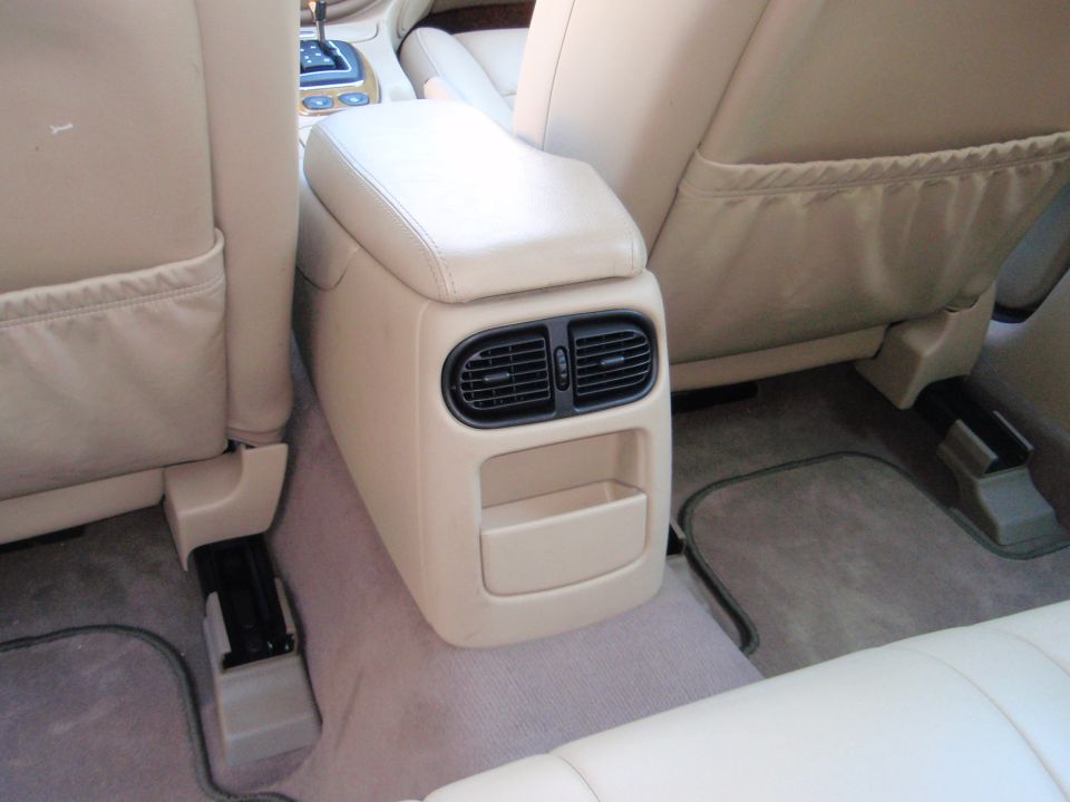 Interior shot of car's rear center console with air vents and storage, between the front and rear seats