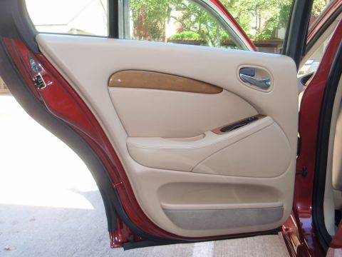 2000 Jaguar S-Type - The interior door panel features wood trim accents and beige upholstery, with the door ajar.