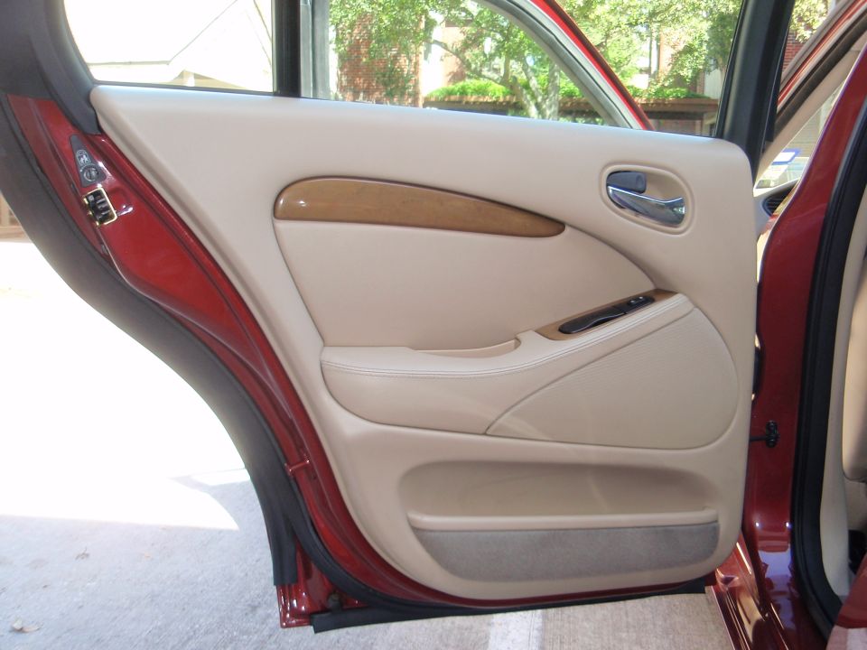 Interior door panel with wood trim and beige upholstery