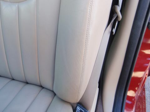 2000 Jaguar S-Type - Close-up of a car's interior, showing the texture and stitching of the beige leather seats.