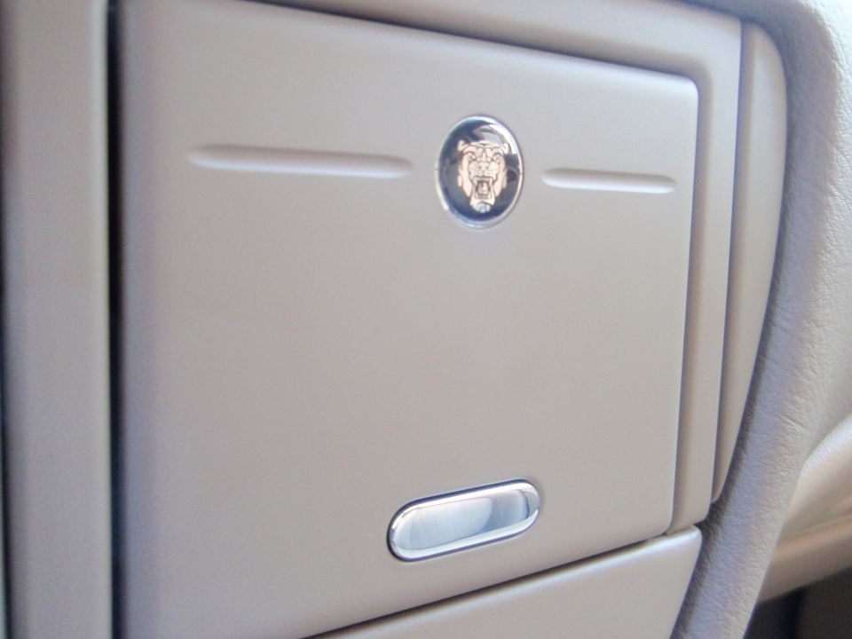 Jaguar emblem on a beige center console compartment