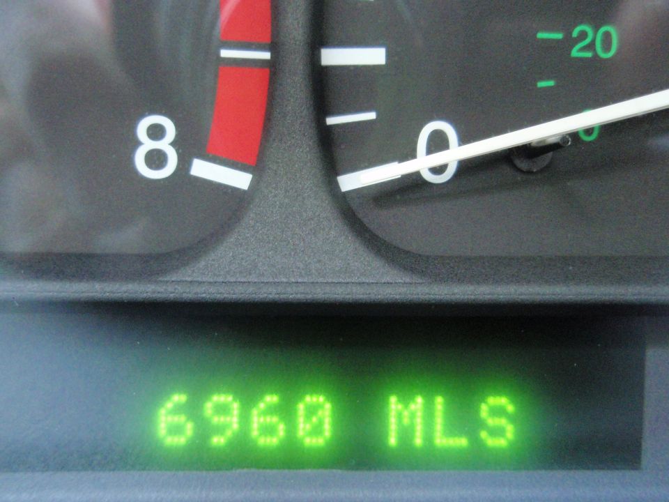 Car dashboard with speedometer and odometer showing 6960 miles