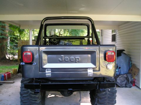 1978 Ford Bronco - This Jeep CJ-7 is parked under a carport, showing its rear end and roll bar.