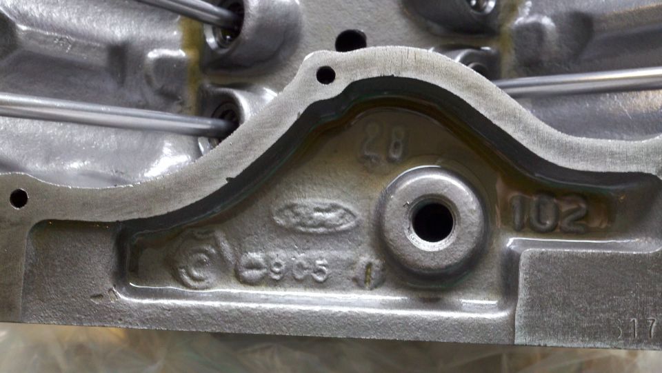 Close-up of a metal engine component with Ford logo and numbers cast into it