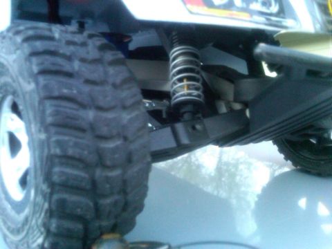 1986 Ford Bronco - Detail of a remote control car's suspension system and off-road tire.
