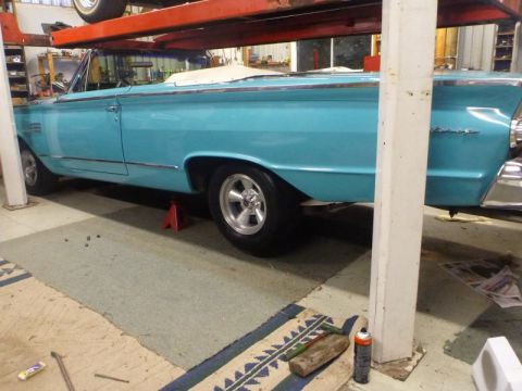 1964 Mercury Monterey - Side view of a blue 1964 Mercury Monterey convertible undergoing service on a lift.