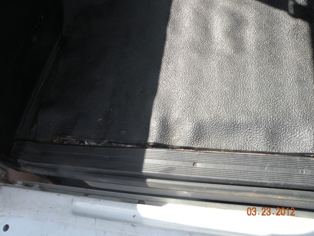Black textured floor mat and door sill inside a vehicle