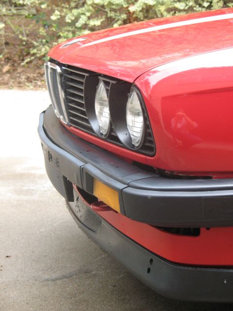 1986 BMW 3 Series - Close-up of the front grille and bumper of a red BMW 3 Series.